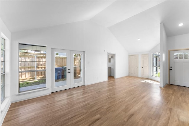 unfurnished living room with wood finished floors, recessed lighting, french doors, and high vaulted ceiling