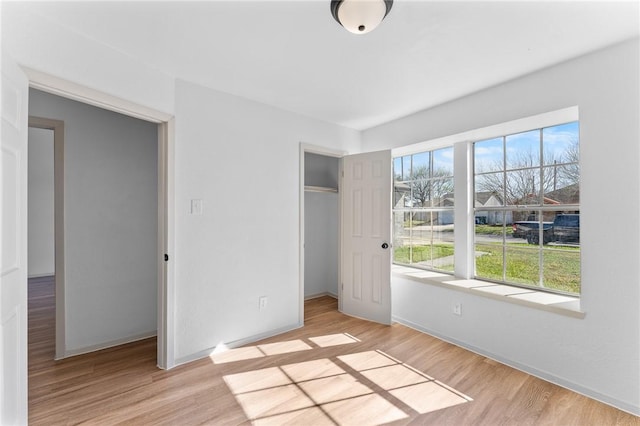 unfurnished bedroom featuring light wood-type flooring and a closet