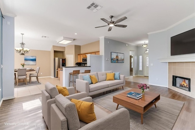 7206 Spanish Wood Dr, Corpus Christi, TX 78414 - living area with light wood finished floors, visible vents, crown molding, and ceiling fan with notable chandelier