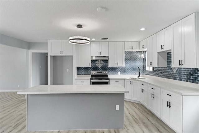 kitchen with white cabinetry, decorative light fixtures, and stainless steel electric stove