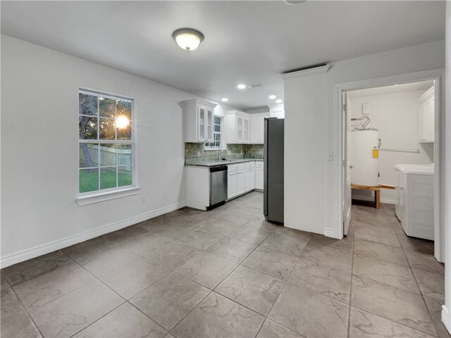 kitchen featuring white cabinetry, separate washer and dryer, water heater, decorative backsplash, and appliances with stainless steel finishes