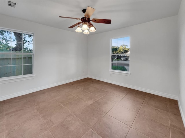 tiled empty room featuring ceiling fan