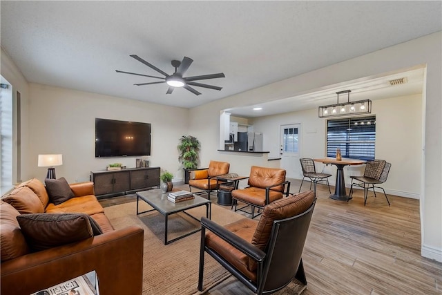 living room with ceiling fan and light wood-type flooring