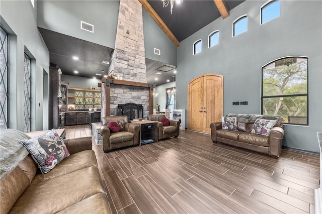 living room featuring a fireplace, hardwood / wood-style floors, high vaulted ceiling, and beamed ceiling