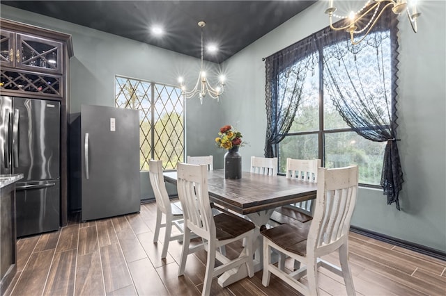 dining room with a notable chandelier, a healthy amount of sunlight, and wood-type flooring