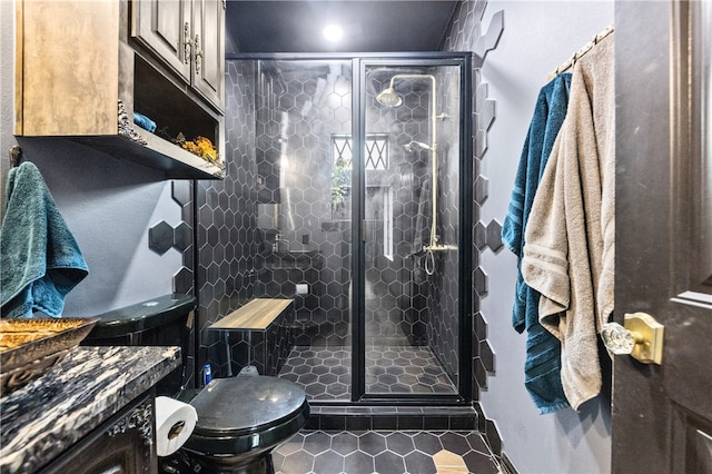 bathroom with tile patterned flooring, vanity, toilet, and an enclosed shower