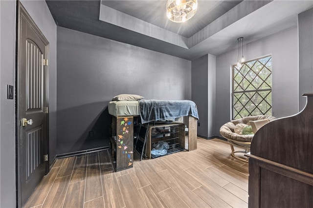 interior space with a tray ceiling and hardwood / wood-style flooring