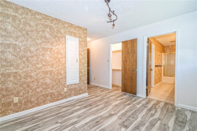 5490 County Road 73, Robstown, TX 78380 - unfurnished bedroom with wood finished floors, a textured ceiling, baseboards, and ensuite bathroom
