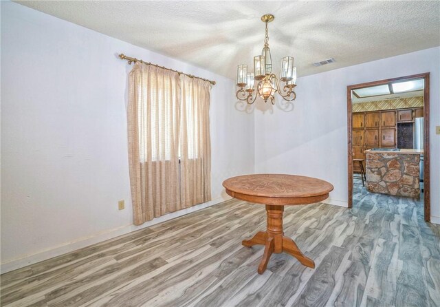 5490 County Road 73, Robstown, TX 78380 - dining area featuring wood finished floors, a chandelier, baseboards, and a textured ceiling