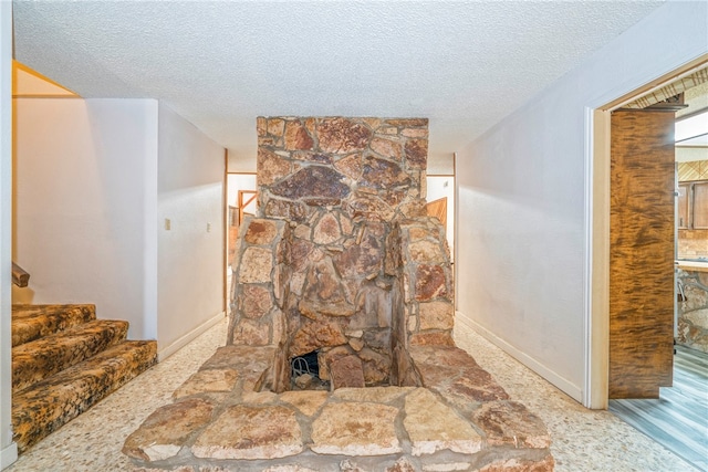 details featuring a stone fireplace, carpet, and a textured ceiling