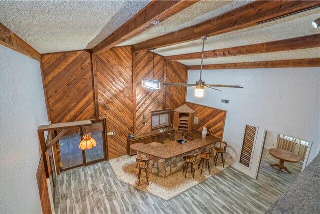 5490 County Road 73, Robstown, TX 78380 - dining area featuring wood finished floors, wooden walls, a textured ceiling, beam ceiling, and a ceiling fan