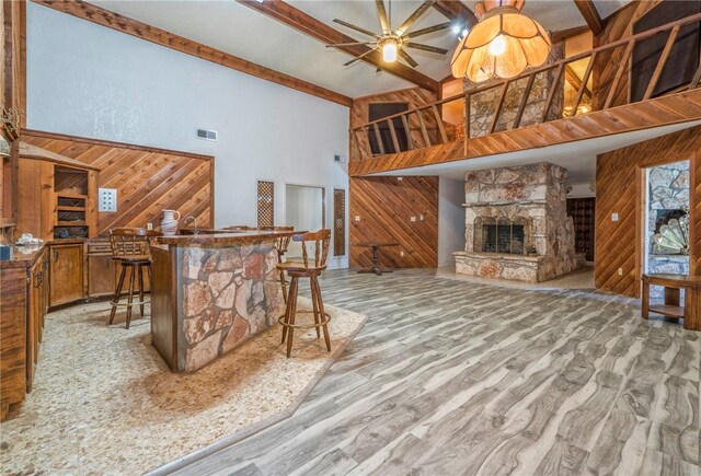 5490 County Road 73, Robstown, TX 78380 - living area featuring wooden walls, a high ceiling, a bar, light wood-type flooring, and a fireplace