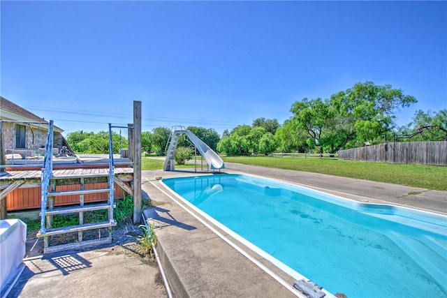 view of pool with a patio, a yard, and a water slide