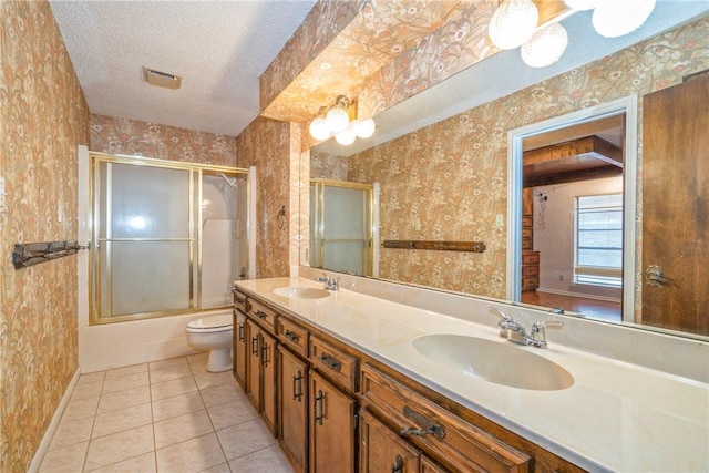 5490 County Road 73, Robstown, TX 78380 - bathroom featuring tile patterned floors, a textured ceiling, toilet, double vanity, and wallpapered walls