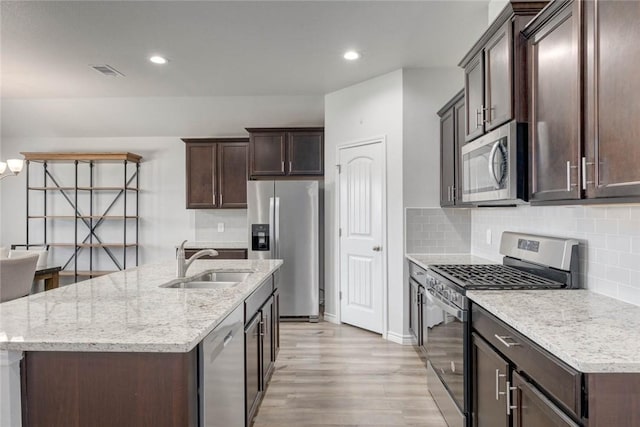 2721 Excelsior Blvd, Corpus Christi, TX 78415 - kitchen featuring stainless steel appliances, light wood-style flooring, dark brown cabinets, tasteful backsplash, and recessed lighting
