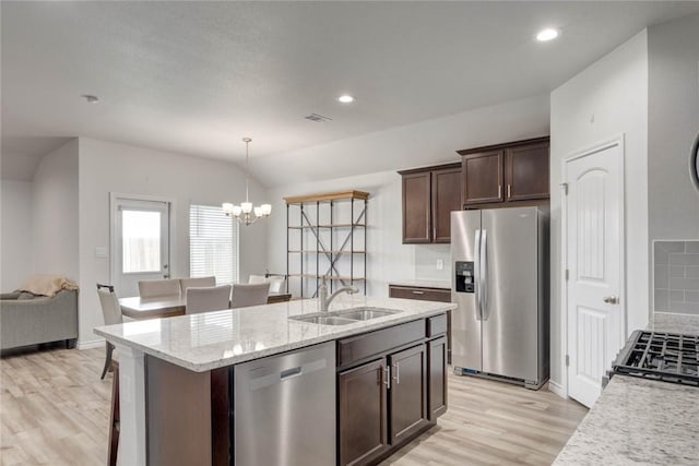 2721 Excelsior Blvd, Corpus Christi, TX 78415 - kitchen featuring appliances with stainless steel finishes, light wood-type flooring, a chandelier, dark brown cabinets, and a center island with sink