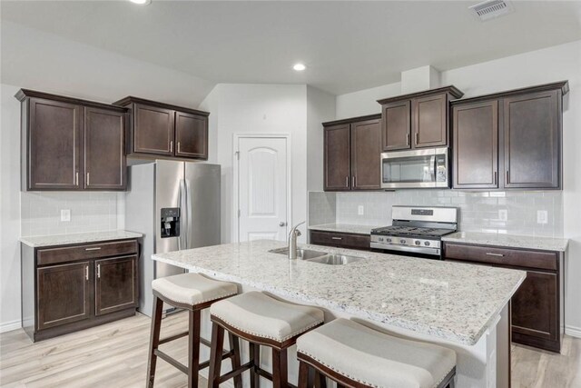 2721 Excelsior Blvd, Corpus Christi, TX 78415 - kitchen with stainless steel appliances, dark brown cabinets, light wood-style flooring, a breakfast bar, and recessed lighting