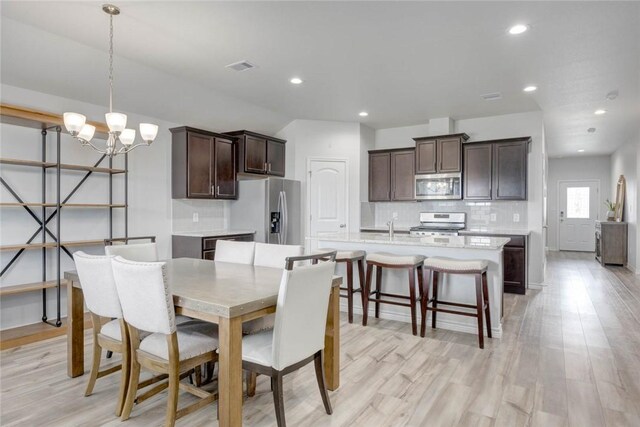 2721 Excelsior Blvd, Corpus Christi, TX 78415 - dining area featuring a chandelier, recessed lighting, light wood-style floors, and vaulted ceiling