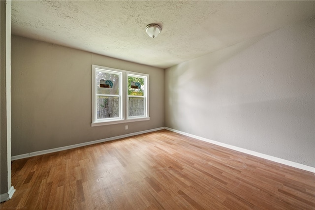 unfurnished room with hardwood / wood-style floors and a textured ceiling