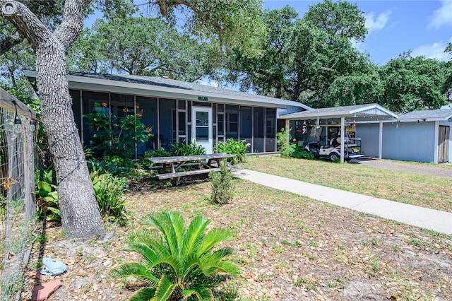 view of front of property featuring a sunroom and a front lawn