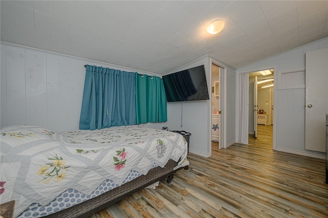 bedroom with hardwood / wood-style floors and vaulted ceiling