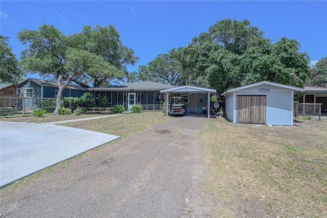 19 Estates Dr, Rockport, TX 78382 - view of front of house featuring a shed, a detached carport, an outbuilding, and asphalt driveway