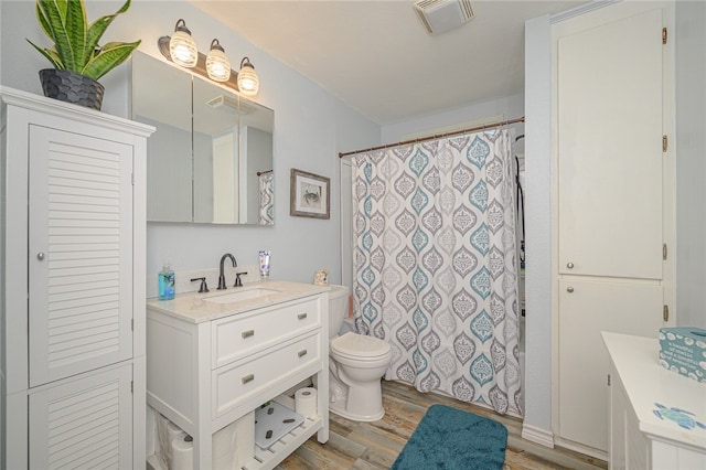 bathroom with toilet, vanity, and hardwood / wood-style floors