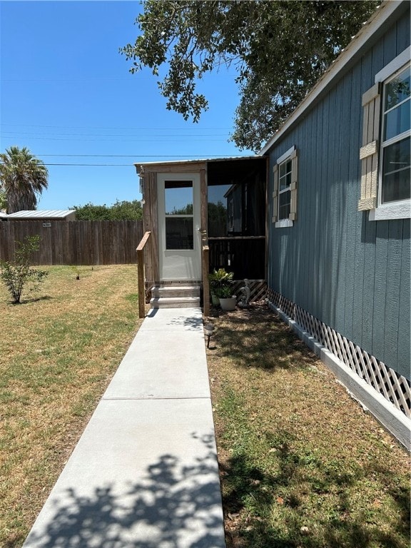 view of exterior entry featuring a lawn