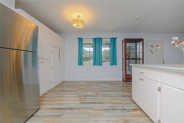 kitchen with white cabinetry, light hardwood / wood-style floors, and stainless steel refrigerator