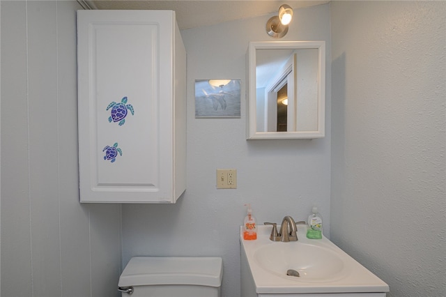 bathroom with vanity, toilet, and lofted ceiling