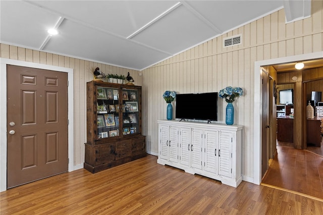 interior space with wood walls, vaulted ceiling, and hardwood / wood-style flooring