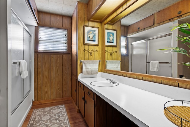 bathroom featuring wood walls, vanity, hardwood / wood-style flooring, and a shower with door