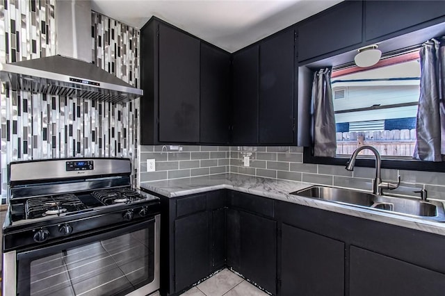 4122 Barnes St, Corpus Christi, TX 78411 - kitchen with black gas stove, dark cabinetry, wall chimney exhaust hood, and tasteful backsplash