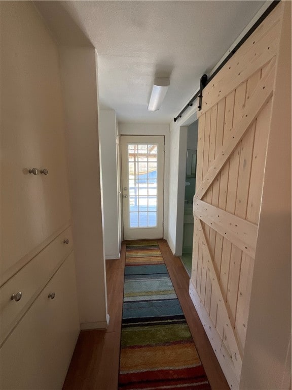 doorway with a barn door and hardwood / wood-style flooring