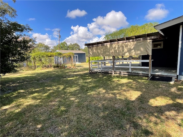 view of yard featuring a storage unit and a deck