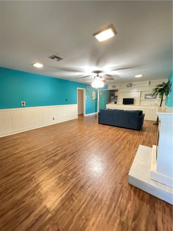 unfurnished living room featuring ceiling fan and wood-type flooring