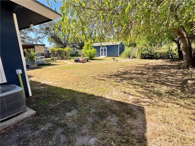 view of yard featuring central AC unit and a storage unit