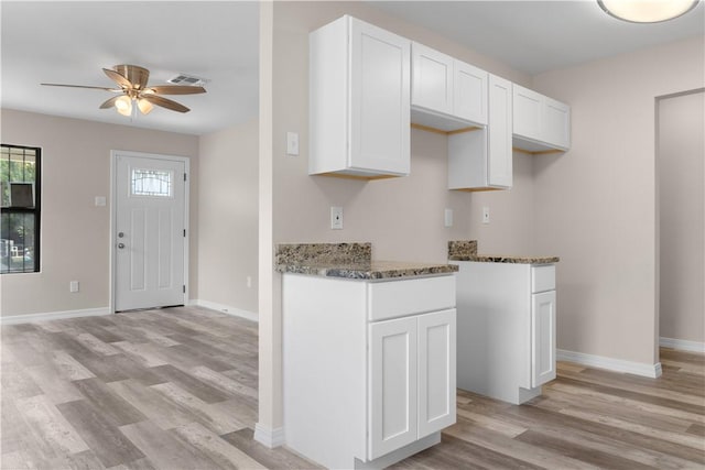 4649 Dodd Dr, Corpus Christi, TX 78415 - kitchen featuring light wood-type flooring, dark stone counters, a ceiling fan, and white cabinets
