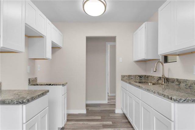 4649 Dodd Dr, Corpus Christi, TX 78415 - kitchen with light wood finished floors, stone countertops, and white cabinets