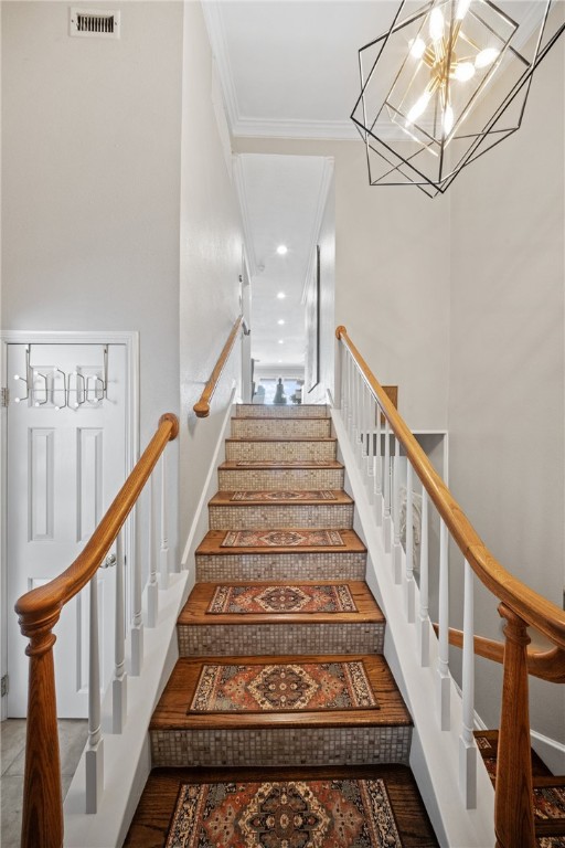 4270 Ocean Dr Unit 11, Corpus Christi, TX 78411 - staircase with ornamental molding and a chandelier