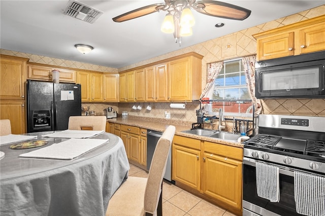 kitchen featuring light tile patterned flooring, sink, decorative backsplash, and black appliances