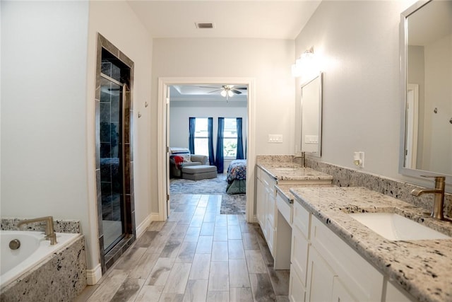 bathroom featuring ceiling fan, vanity, and shower with separate bathtub