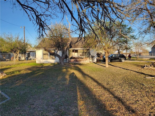 view of front facade with stucco siding, a front lawn, and fence