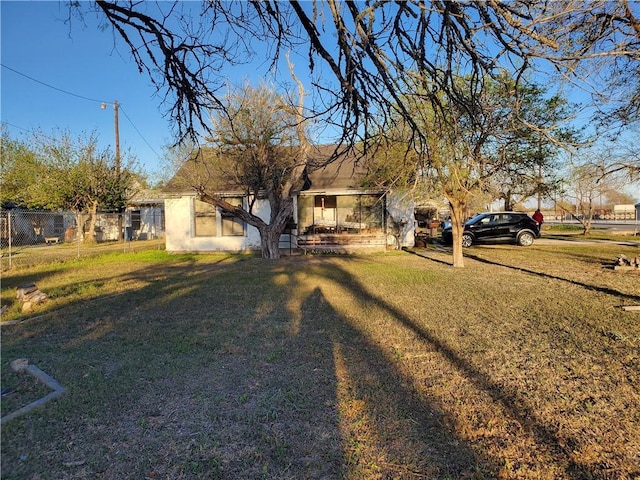 view of front facade featuring stucco siding, a front lawn, and fence