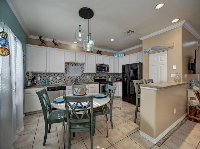 kitchen featuring appliances with stainless steel finishes, pendant lighting, white cabinets, a kitchen bar, and kitchen peninsula