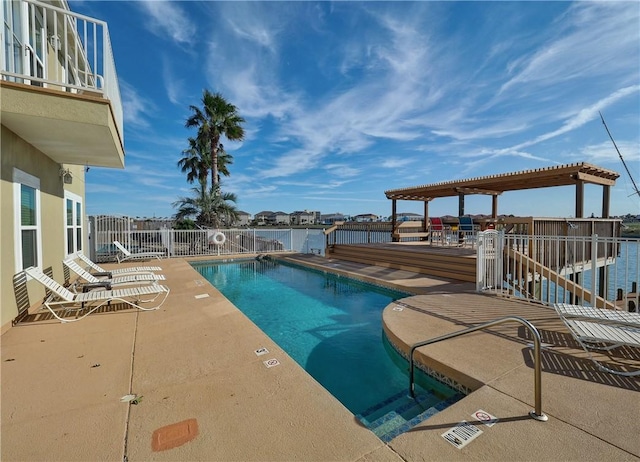 view of swimming pool featuring a pergola, a patio area, and a water view