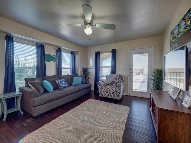 living room featuring a textured ceiling, plenty of natural light, dark hardwood / wood-style floors, and ceiling fan