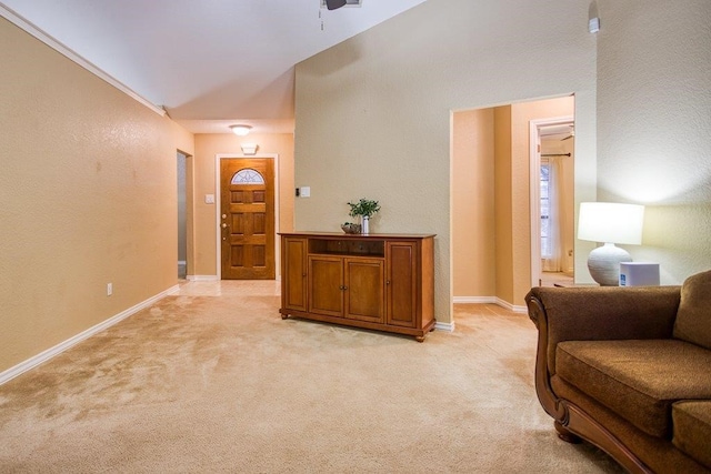 entryway with baseboards, a textured wall, and light colored carpet