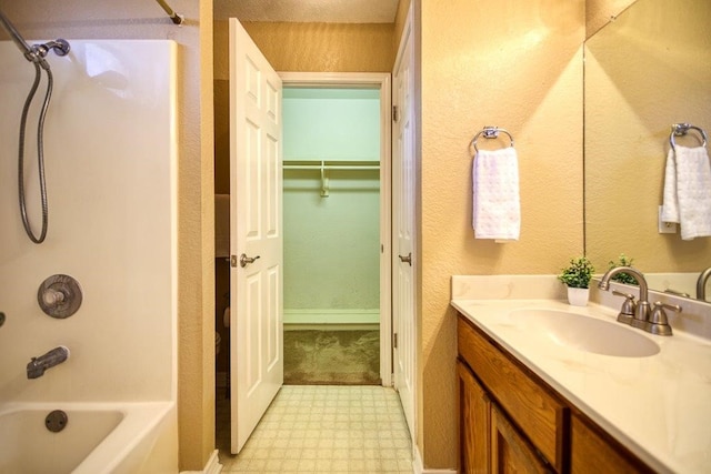 full bathroom with a textured wall, shower / tub combination, vanity, and tile patterned floors