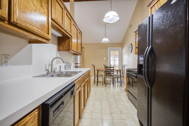 kitchen with a sink, hanging light fixtures, light countertops, brown cabinets, and black appliances